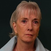 Middle-aged woman with light hair and a sad expression